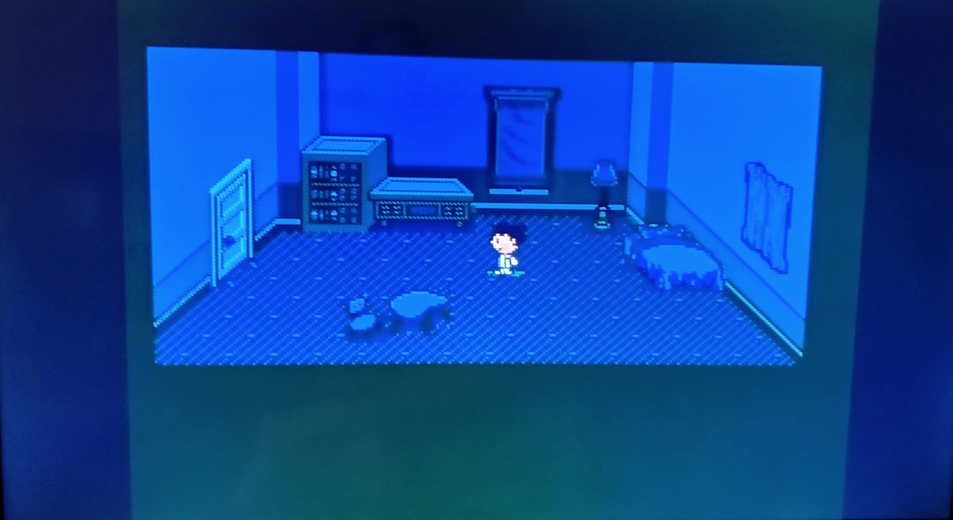 Video game screen showing a character in a room with blue walls and furniture.